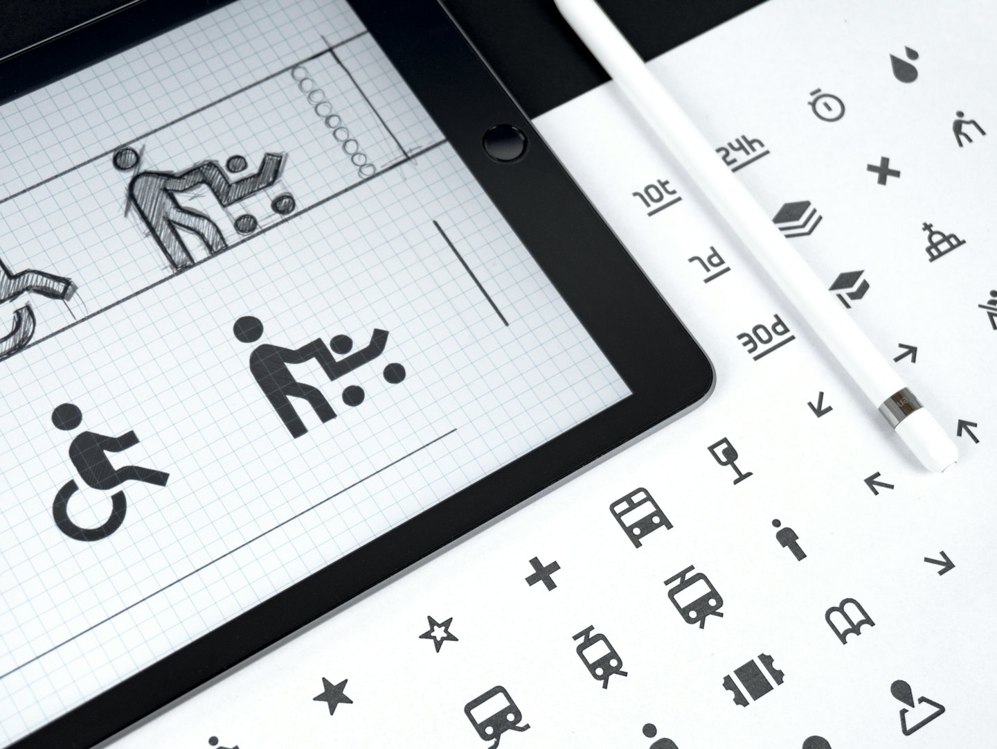 Tablet wyświetla koncepcje projektowania graficznego obok rysika i arkusza ikon.